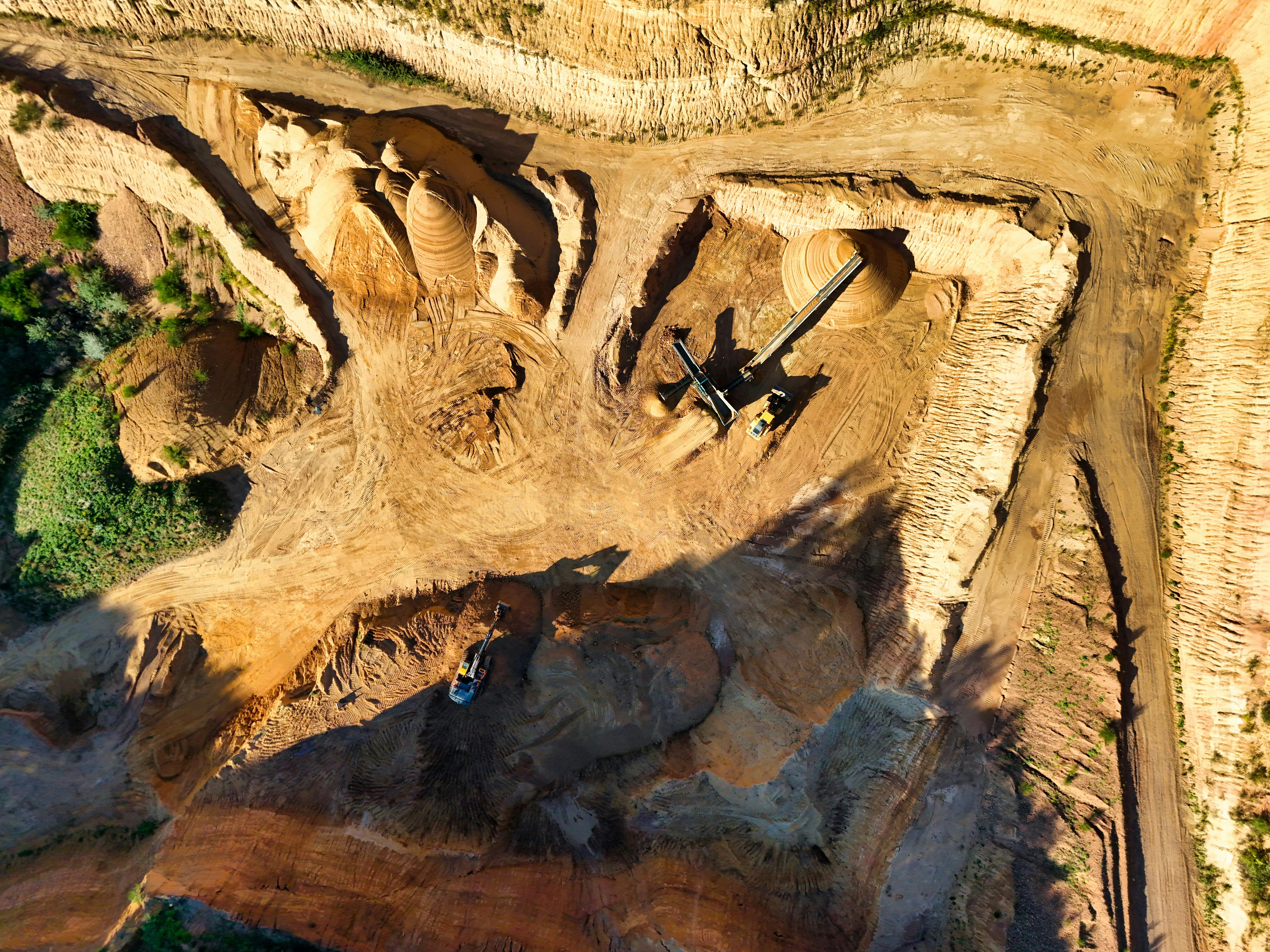 Stunning aerial photo showcasing a large open pit mining operation under sunny conditions.