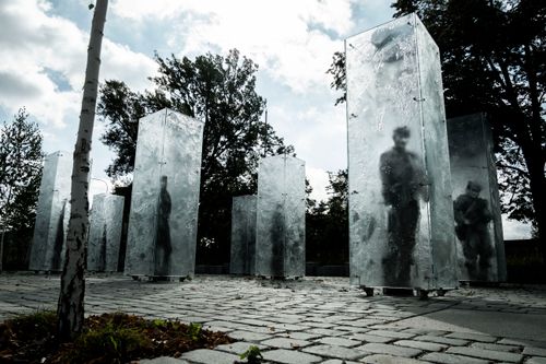 Free Sculptural monument of soldiers in Wrocław, surrounded by trees in an outdoor setting. Stock Photo