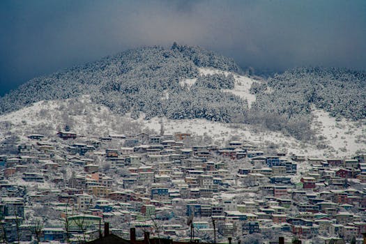 A scenic view of snow-covered houses and the Uludağ Mountain in Bursa, Türkiye during winter.