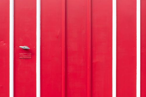 Free A striking red door with white accents creates a bold minimalist aesthetic. Stock Photo