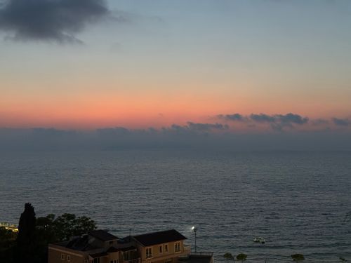 Free Beautiful view of a colorful sunset over the ocean with distant clouds. Stock Photo