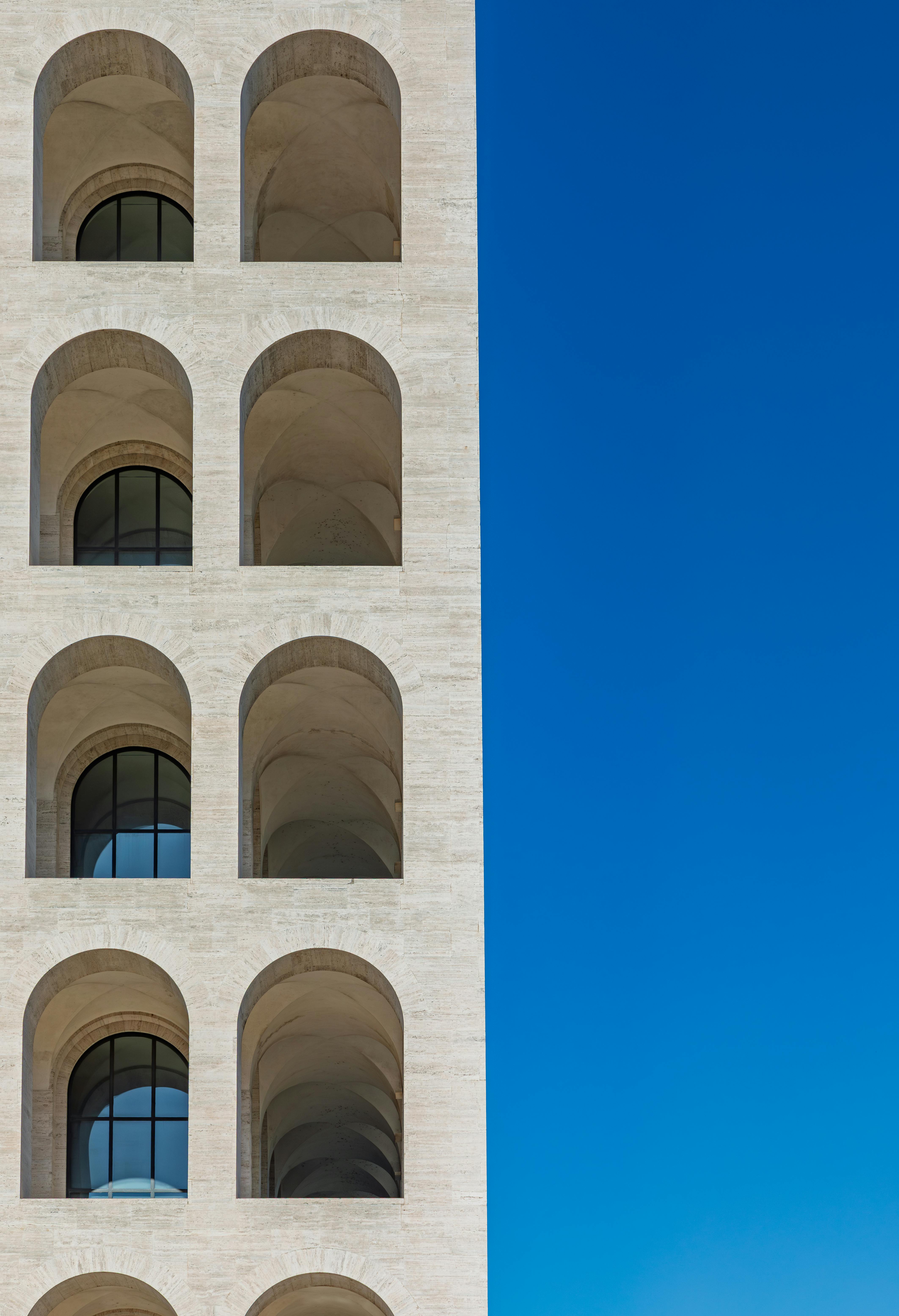 무료 푸른 하늘과 아치가 돋보이는 상징적인 팔라초 델라 치빌타 이탈리아나의 측면 모습입니다. 스톡 사진