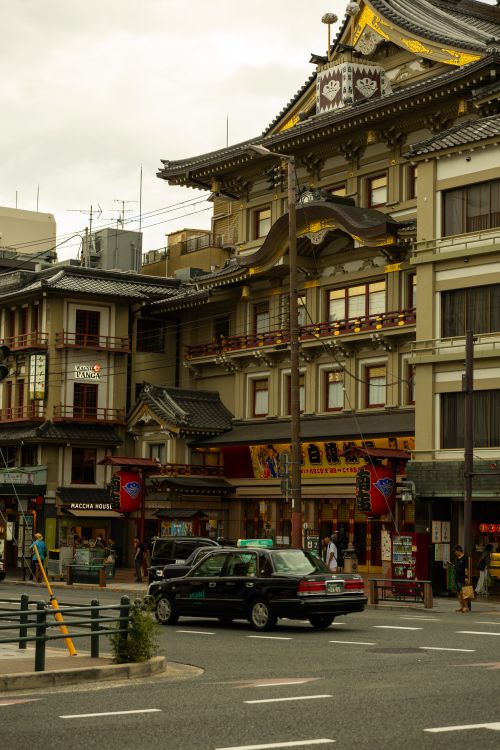 Free Historic Japanese architecture along a bustling city street with a taxi. Stock Photo