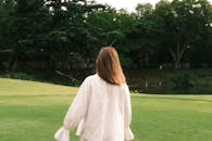 Woman in White Walking in Lush Park Setting