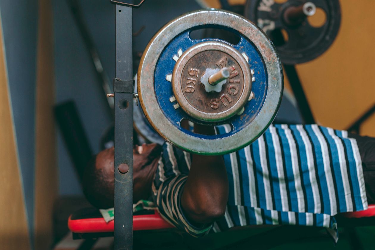 Man performing bench press in indoor gym