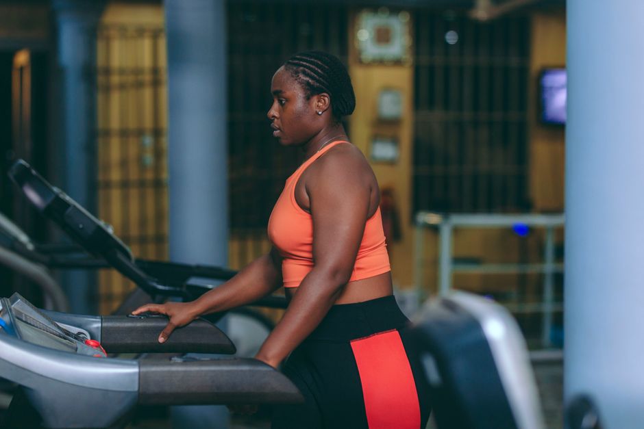 woman running on treadmill watching tablet
