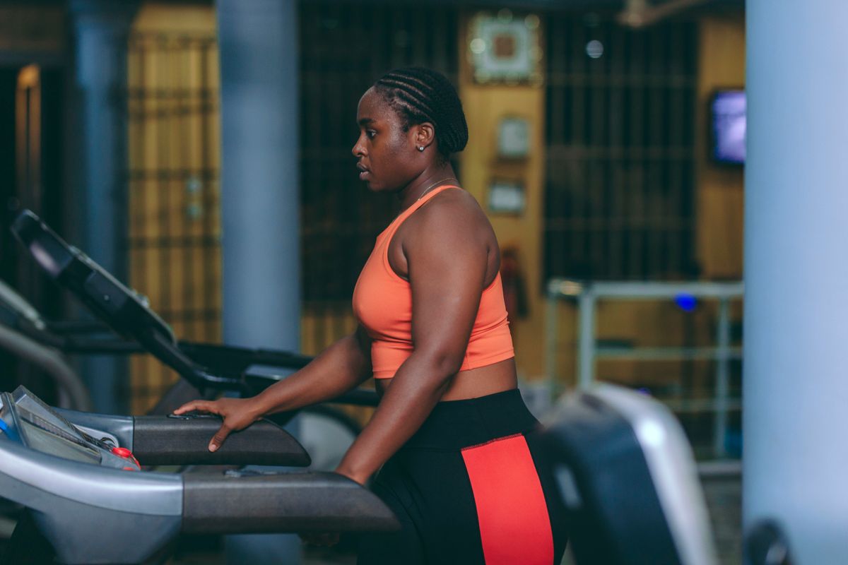 Woman running on a treadmill in a modern indoor gym