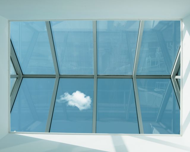 Daylight through a skylight View looking up through a clear glass skylight at a blue sky