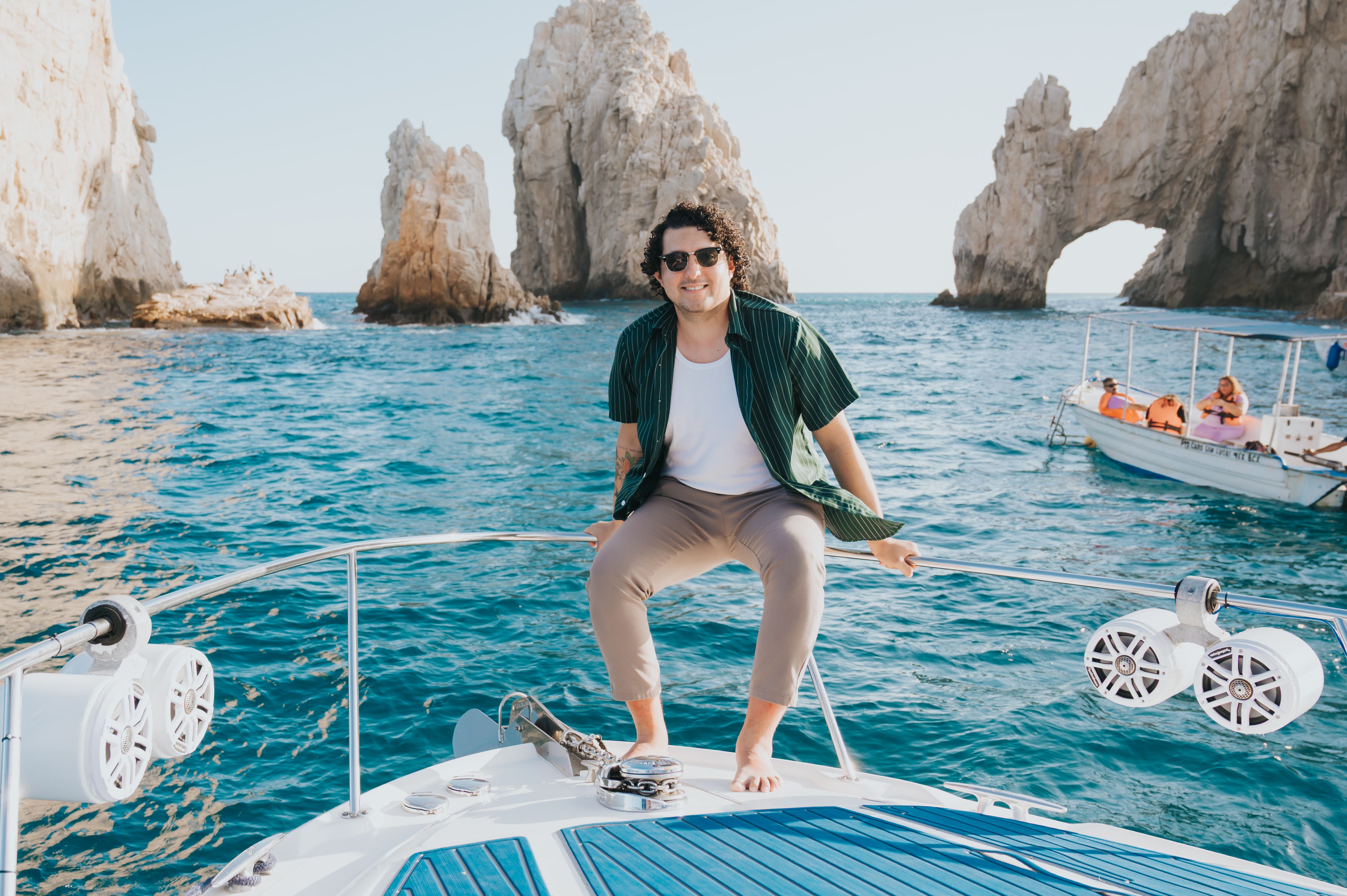 Smiling Man Enjoys Boat Ride Near Famous Arch · Free Stock Photo