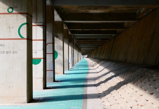 Concrete underpass featuring geometric wall art with angular shadows on a sunny day.