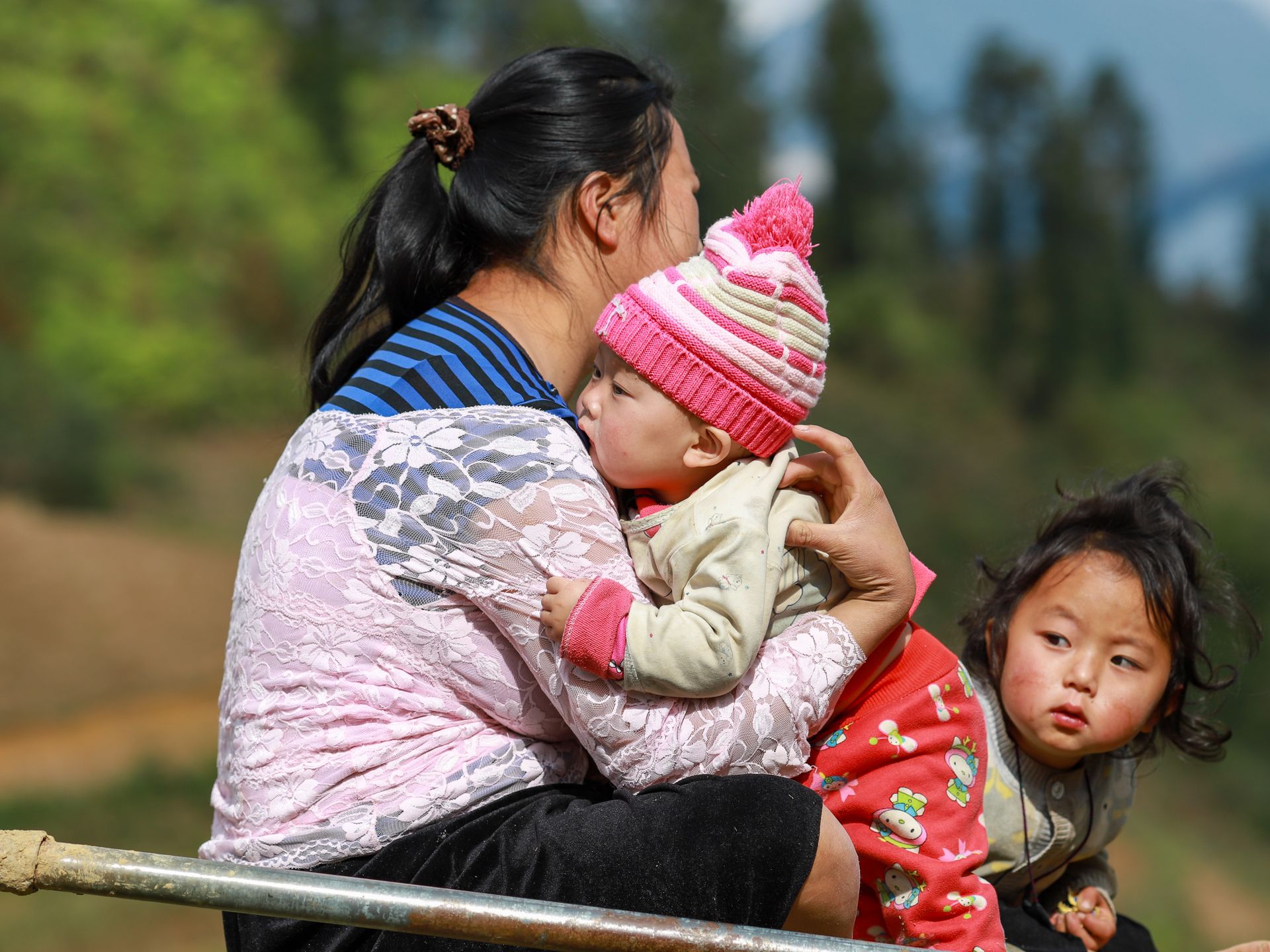 A mother and two children in Lào Cai, Vietnam, showcasing traditional life and culture.