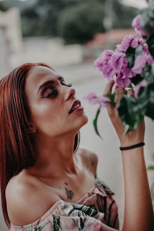 Free Woman Sniffing a Purple-petaled Flowering Plant Stock Photo