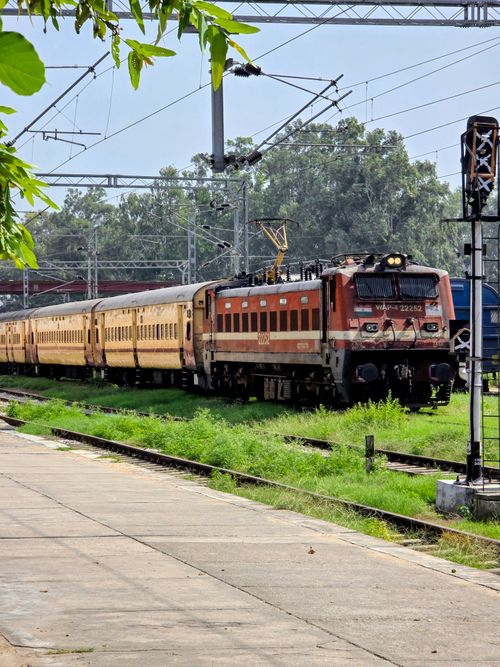 Free A classic Indian Railways train passing through Patiala station surrounded by lush greenery. Stock Photo