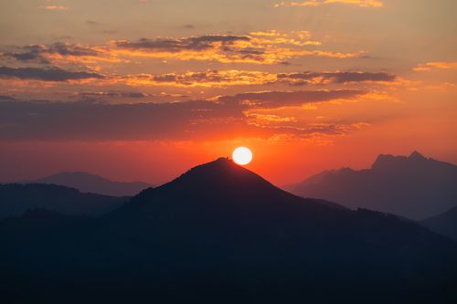 Free Breathtaking sunrise over mountain peaks, capturing an orange sky and tranquil nature scene. Stock Photo
