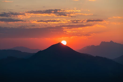 A breathtaking sunrise over mountain peaks, casting warm hues across a vibrant sky.