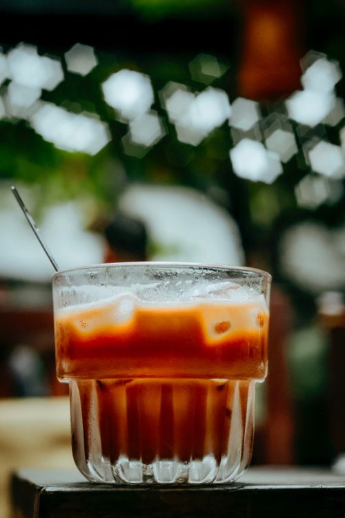 Free Close-up of iced Thai tea in a glass with a spoon and bokeh background. Stock Photo