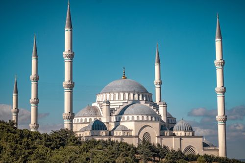 Free A beautiful exterior view of a large mosque with minarets against a clear blue sky. Stock Photo