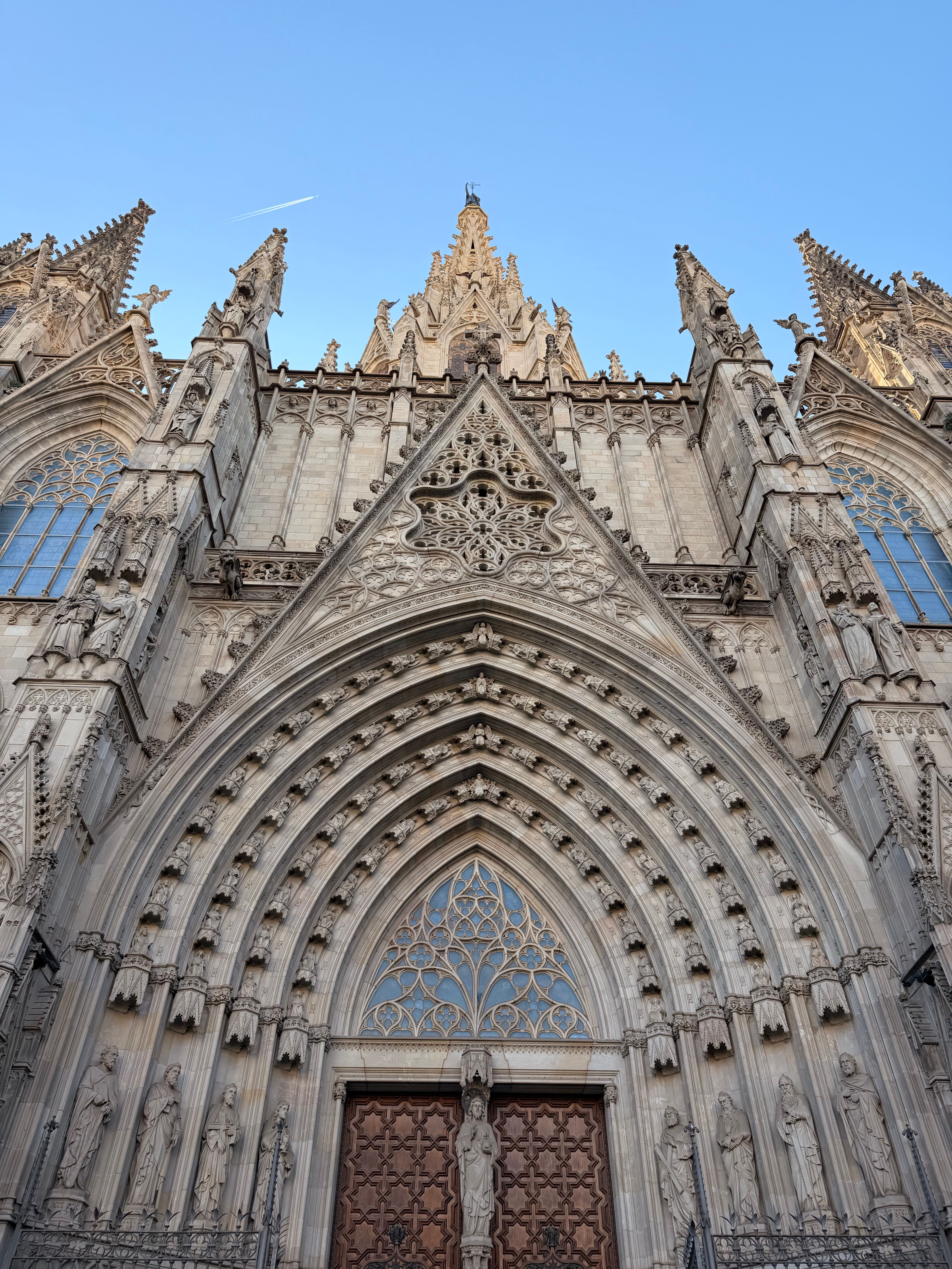 Gratis Detaljert utsikt over den gotiske fasaden til Barcelonas katedral under en klar blå himmel. Arkivbilde