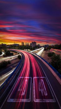 Dynamic highway lights contrast against a vibrant sunset sky in a captivating cityscape.