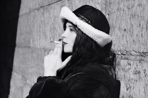 Free Black and white portrait of a woman in a hat smoking outdoors. Stock Photo