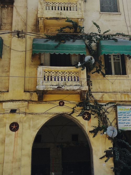 Free Old building facade with green awnings and ivy, showcasing vintage architecture. Stock Photo