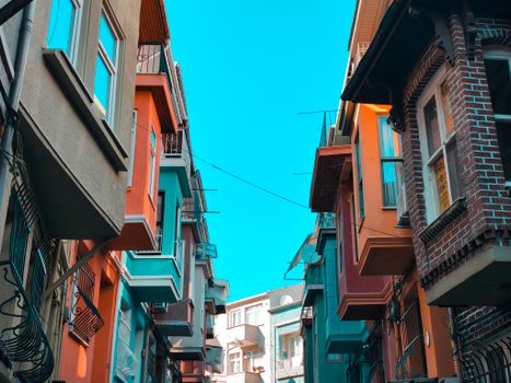 Vibrant buildings with colorful facades in a narrow street under a clear blue sky.