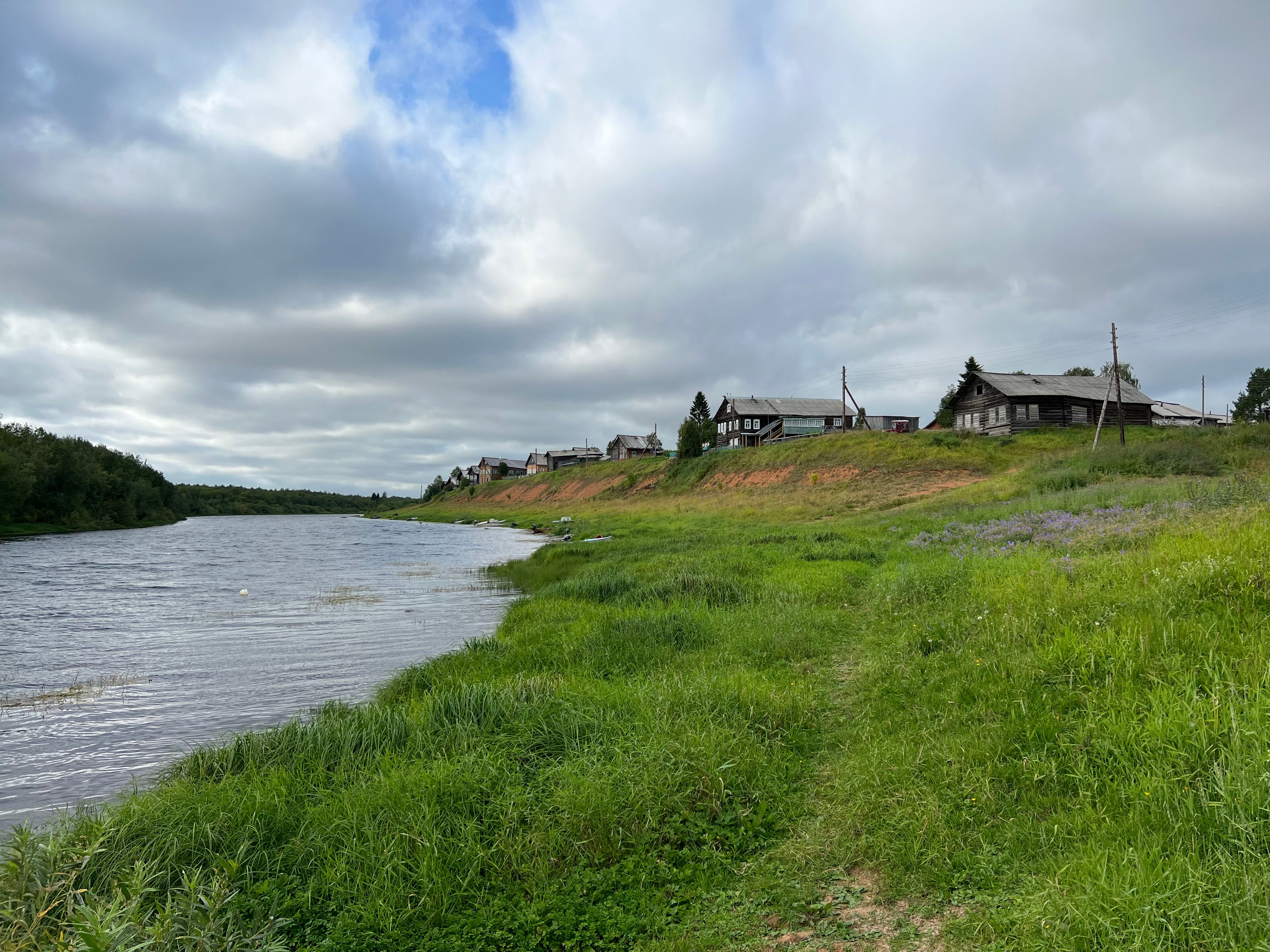 Peaceful riverside village with rustic wooden houses · Free Stock Photo