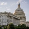 The dome of the United States Capitol building against a bright sky.
