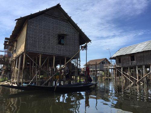 Free Traditional stilt houses over water in Inle Lake, Myanmar, under clear blue skies. Stock Photo