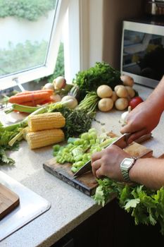 A person chopping fresh vegetables in a bright South African kitchen. Ideal for cooking and culinary themes.