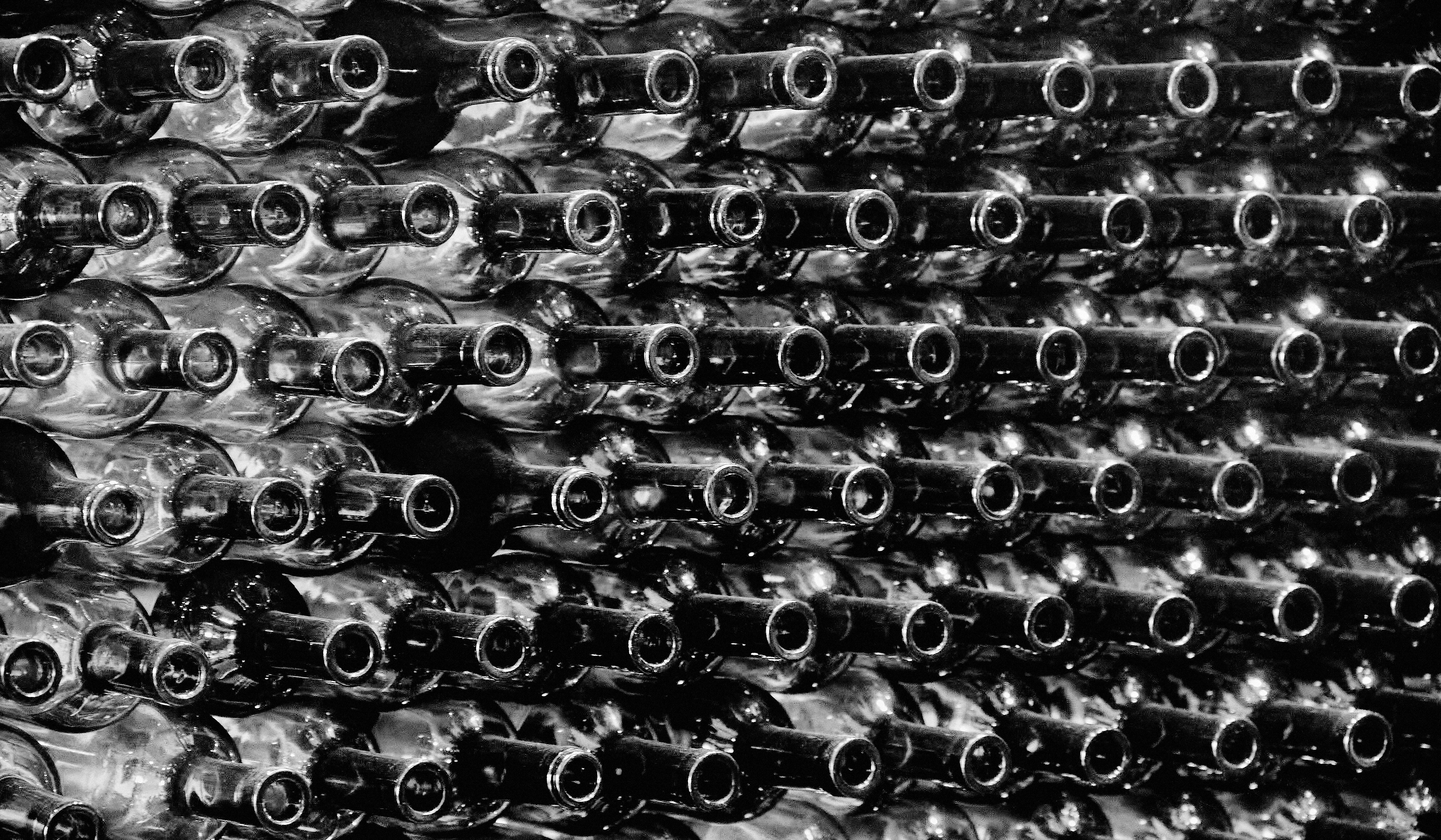 Monochrome image of stacked wine bottles in a cellar, Al Ain, UAE.