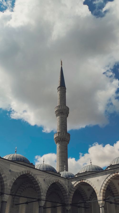Free Majestic minaret reaching towards cloudy sky in Istanbul's iconic mosque landscape. Stock Photo