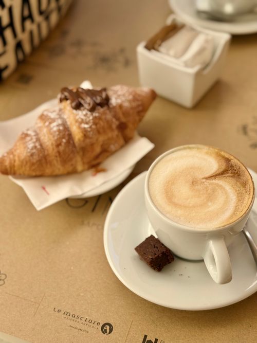 Free A flavorful breakfast with a fresh croissant and creamy cappuccino on a cozy table. Stock Photo