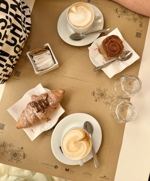 Free Top-down view of a breakfast with pastries and cappuccinos on a table. Stock Photo