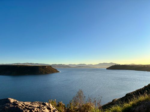 Free Serene sunrise over Lake Umayo in Peru with clear blue sky and calm waters. Stock Photo