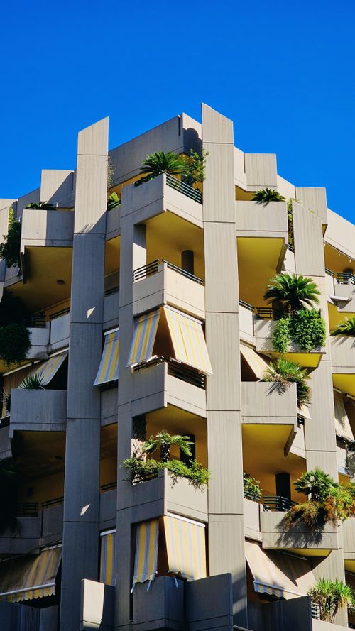Free Striking apartment building with plants and yellow awnings in Polignano a Mare, Italy. Stock Photo