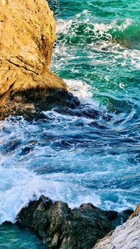 Vibrant waves crashing against the rocky cliffs of Polignano a Mare, Italy.