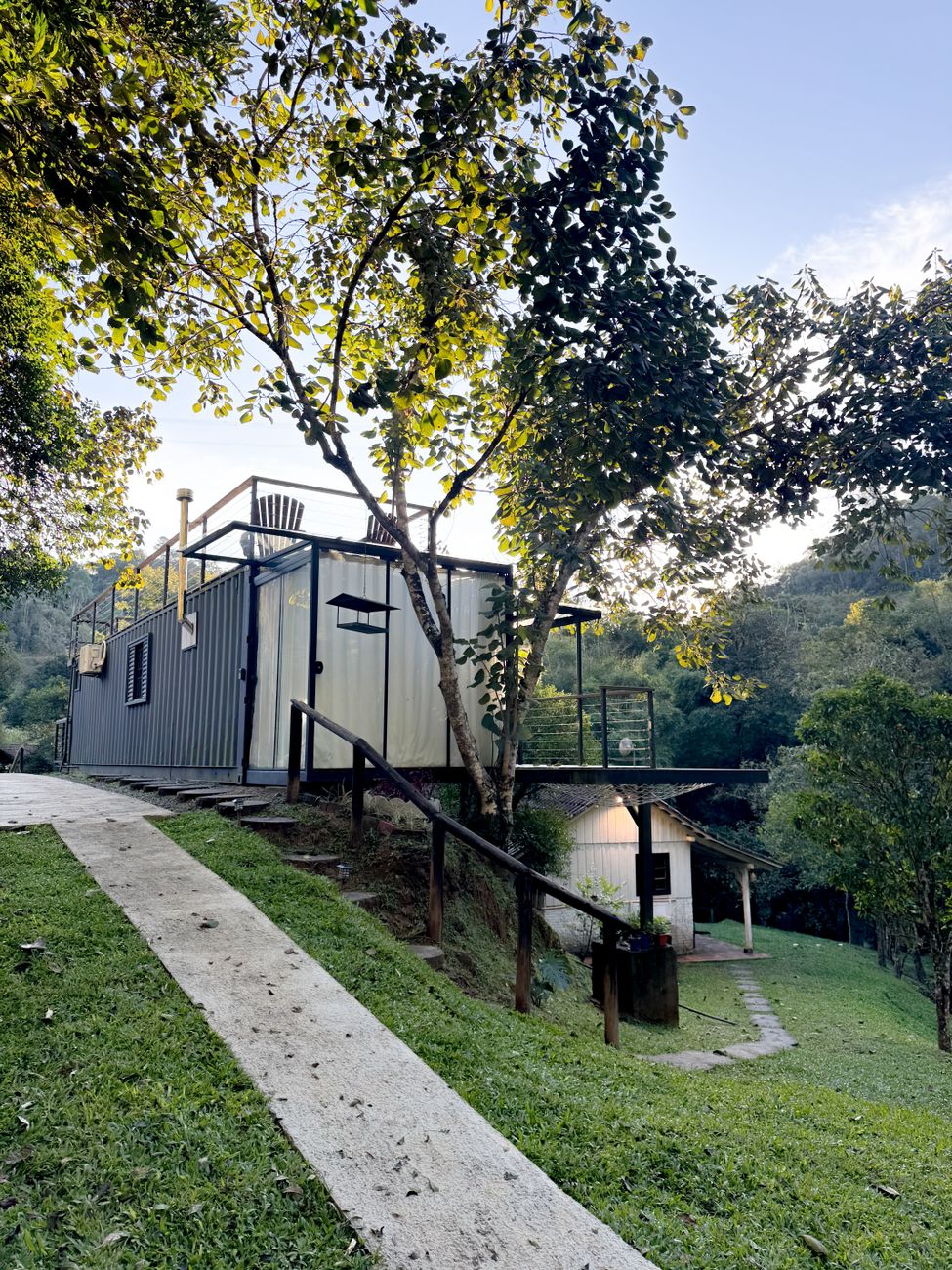 Container home among trees on a hillside, showcasing sustainable living