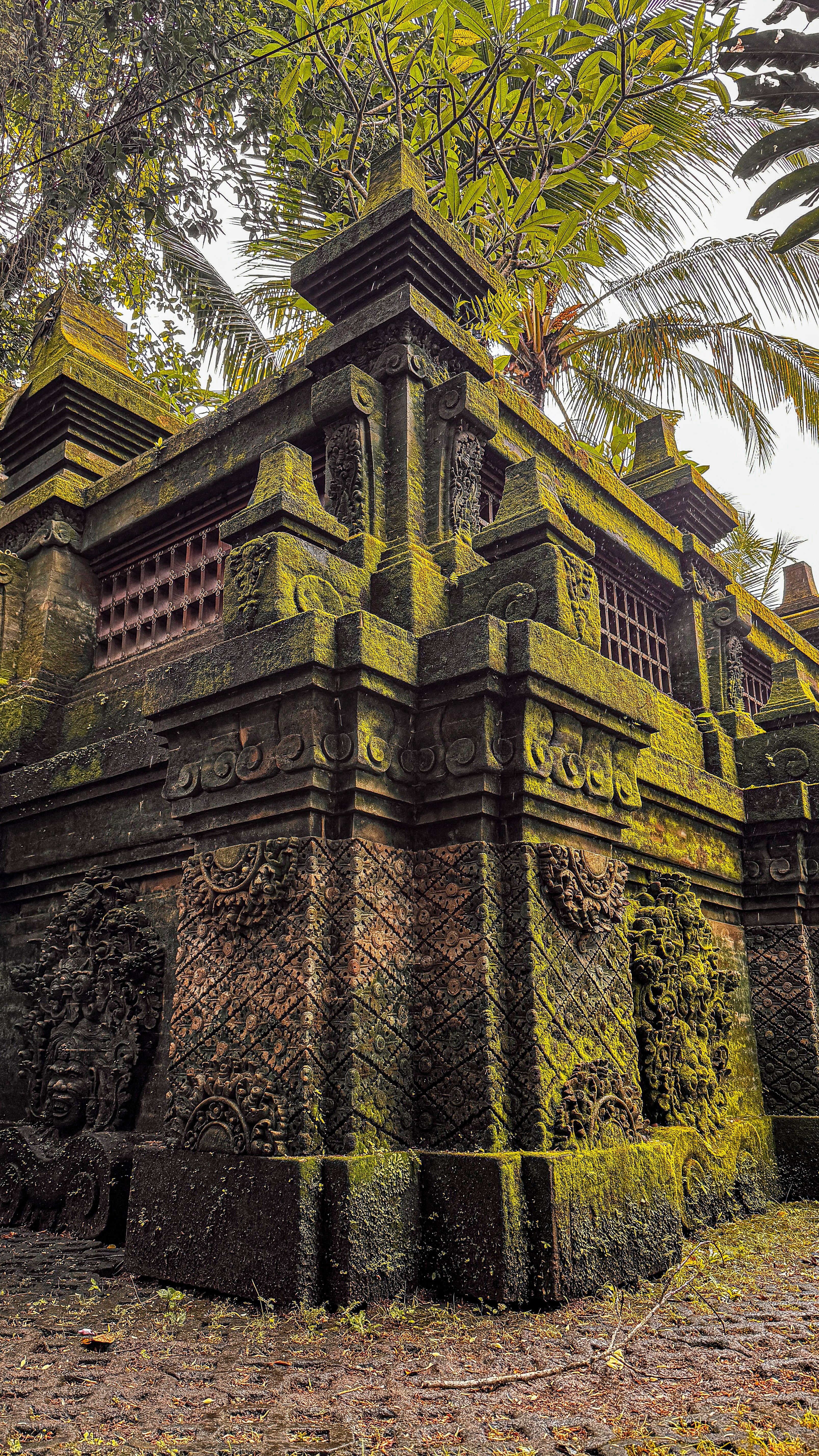 Explore the intricate moss-covered stone carvings of an ancient temple in Bali, Indonesia.