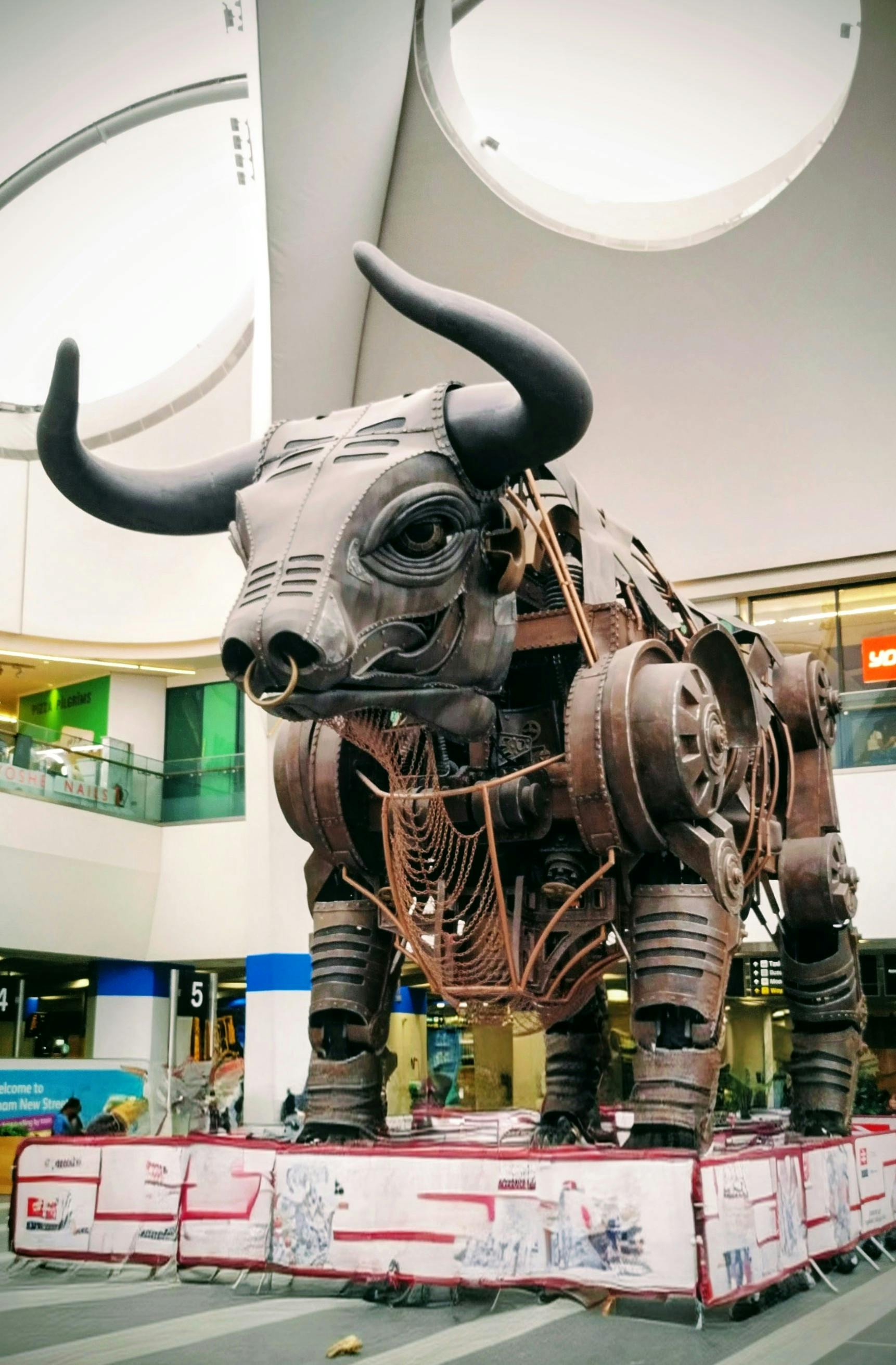 Giant metal bull sculpture at indoor station in Birmingham, UK.