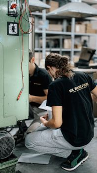 Close-up of a technician working on machinery in a workshop environment.