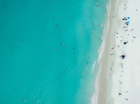 Stunning aerial shot of Perth beach, capturing turquoise waters and vibrant summer activity.