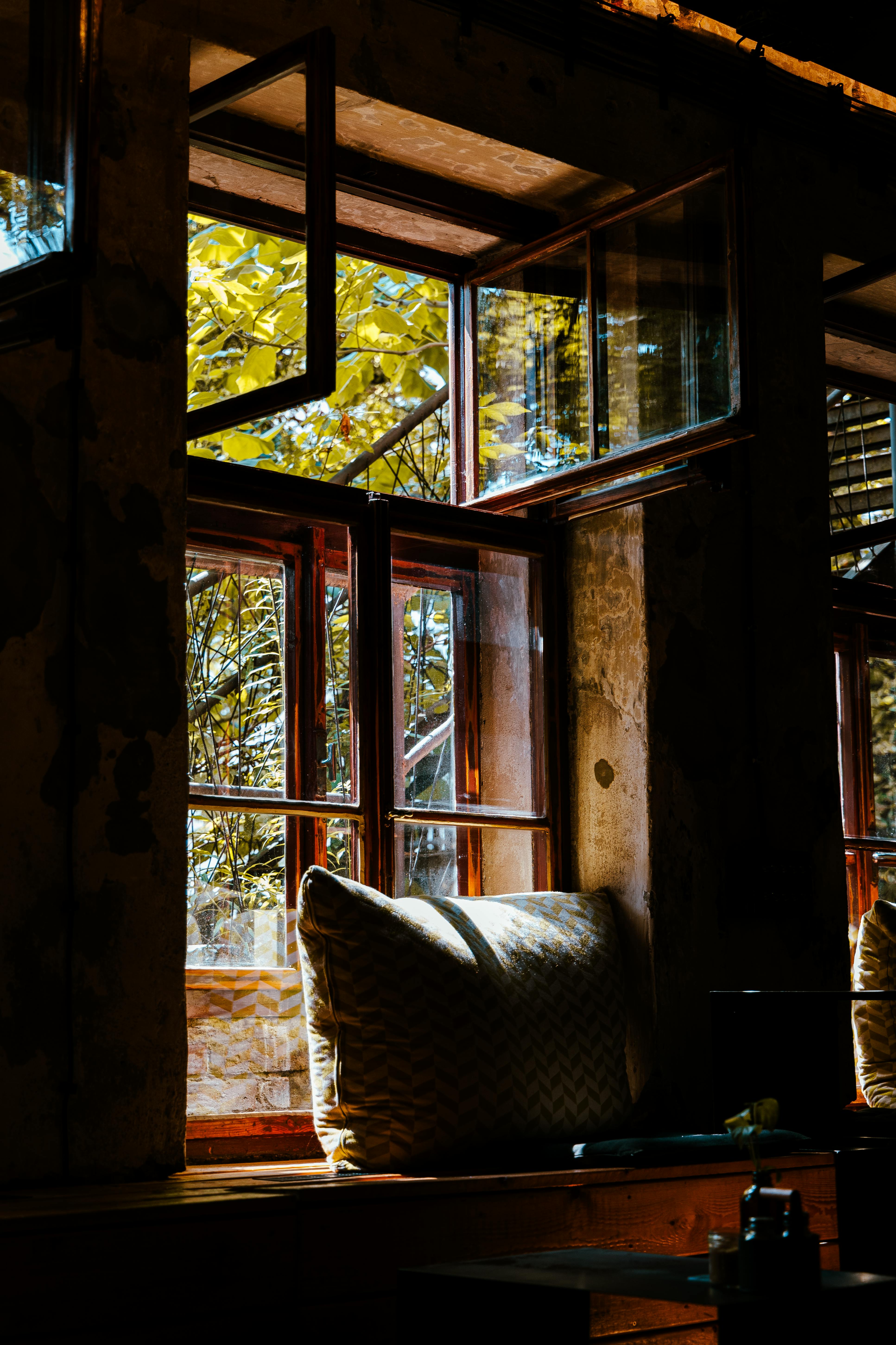 Gratuit Colțișor rustic cald la fereastră, cu lumină naturală și decor vintage pentru o atmosferă confortabilă. Fotografie de stoc