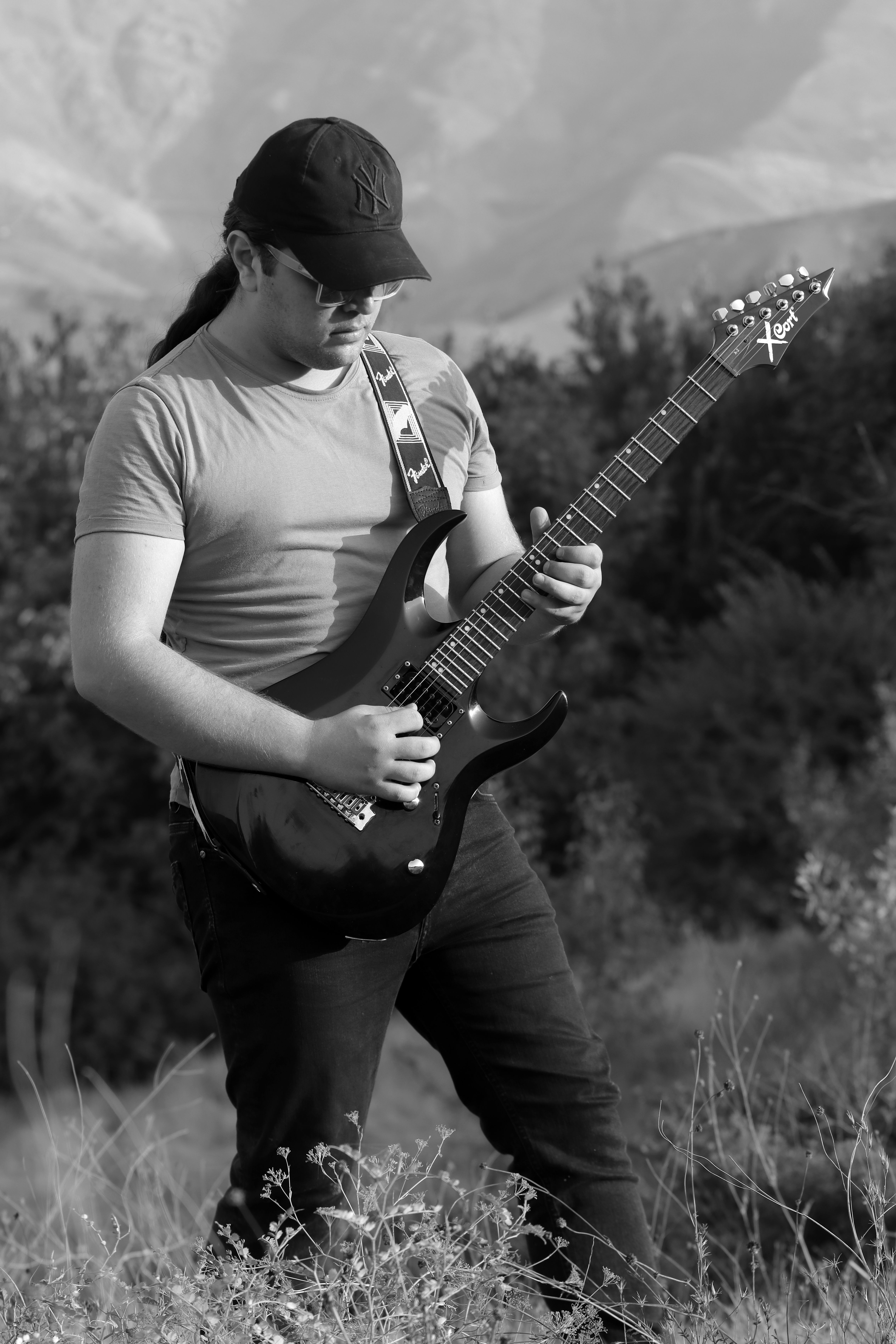 Passionate young musician playing electric guitar in natural setting of Qazvin, Iran.