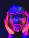 节日上，一位女士在紫外线下画着鲜艳的霓虹灯脸