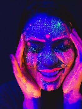 节日上，一位女士在紫外线下画着鲜艳的霓虹灯脸