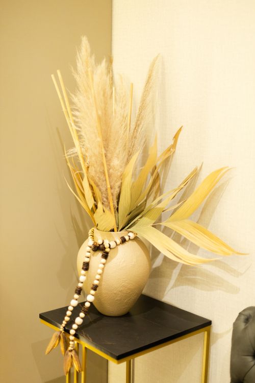 Free Elegant decor with dried grasses in a beige vase, perfect for modern interiors. Stock Photo