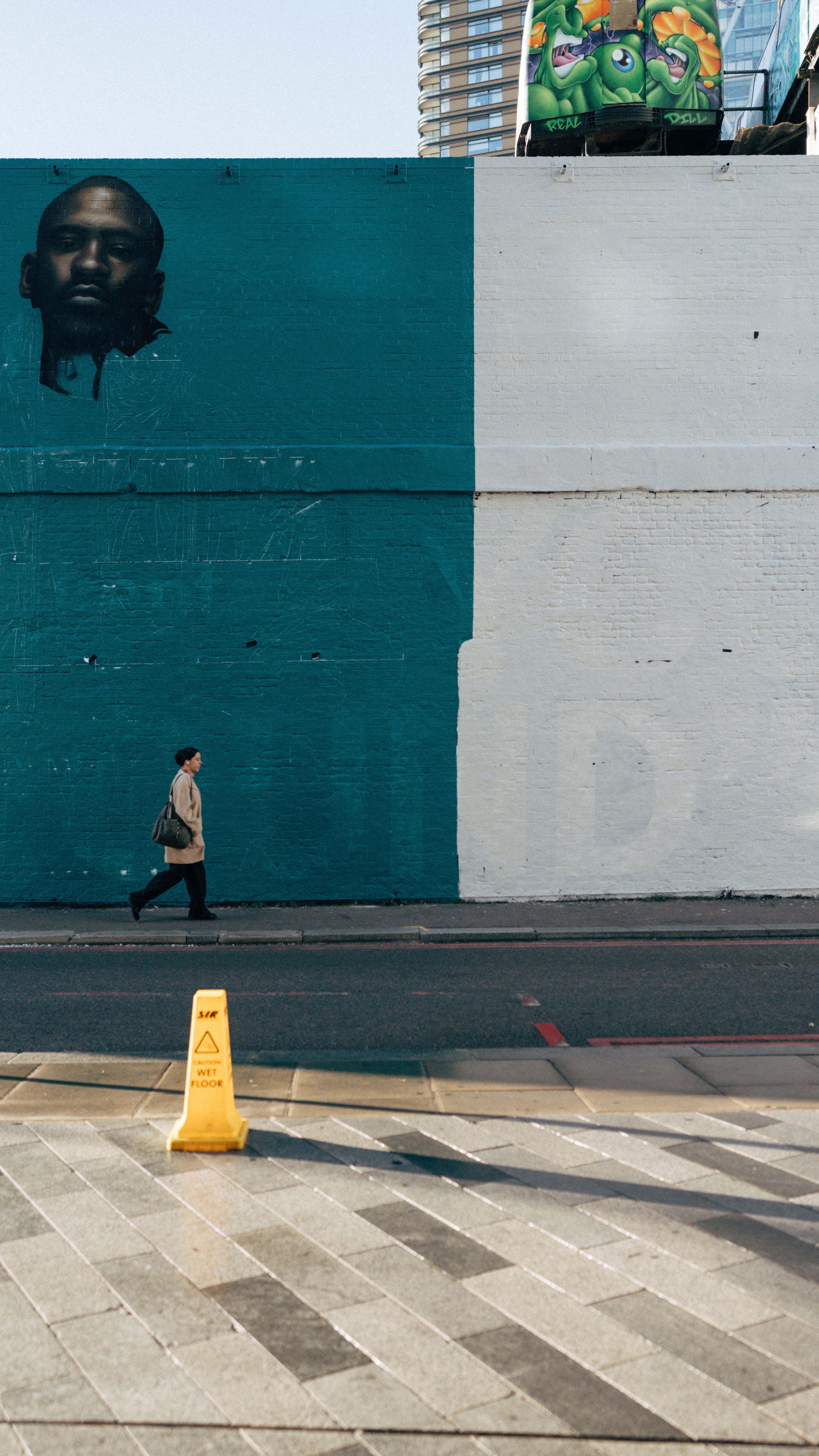 Urban Street Scene with Man Walking by Wall Mural · Free Stock Photo