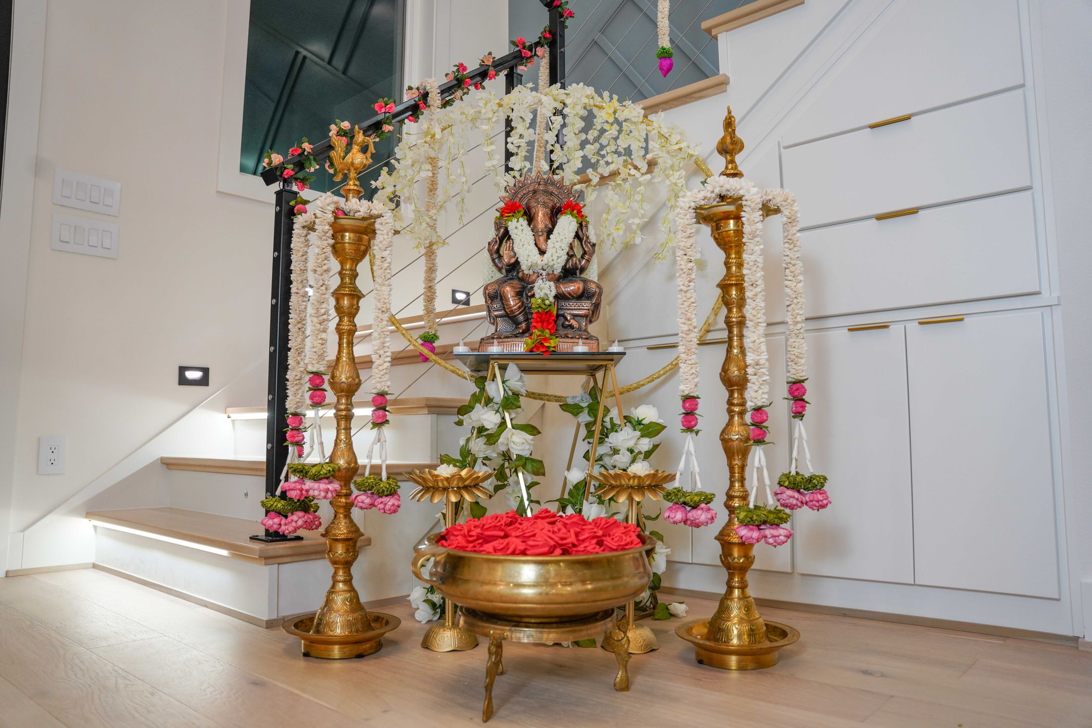 Home pooja setting with brass lamps and floral garlands