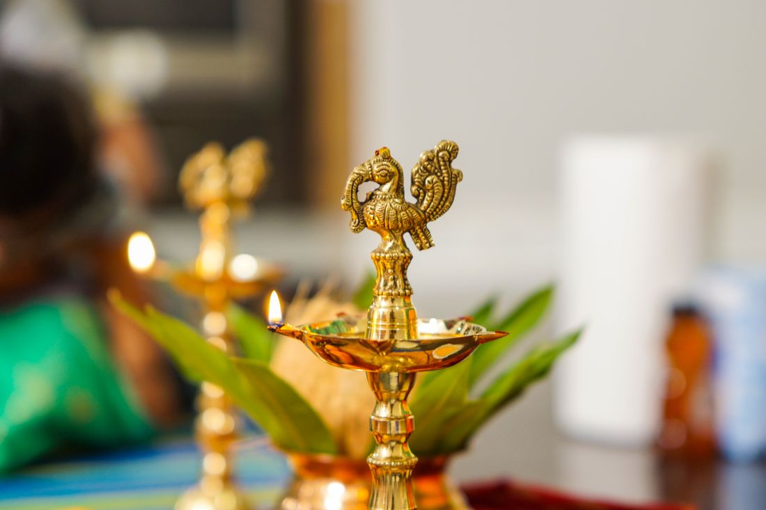 Brass peacock deepam lamp with lit wicks